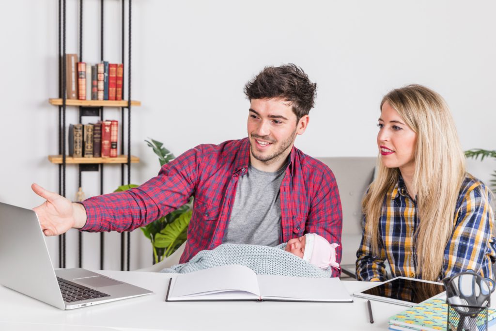 Parents with baby looking at laptop screen
